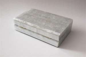 Detail view of pearlescent acrylic clutch with elegant grey marble texture and gold hinges