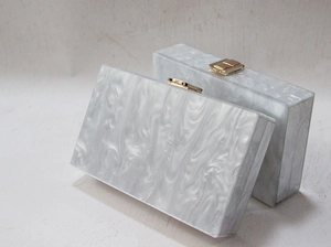 Detail of marble pattern acrylic clutch bags with gold metal clasps for evening gala
