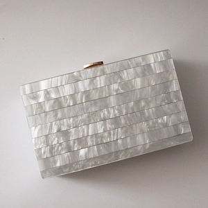 Elegant white pearlescent acrylic clutch bag with marble texture and gold clasp
