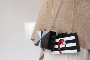 Detail of a hard acrylic box clutch with a metal chain strap and geometric pattern