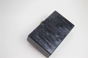 Top view of marble texture acrylic box clutch with golden hexagonal metal clasp