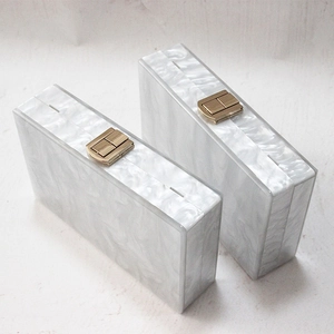 White pearlescent acrylic box clutch bags with golden metal clasps for evening gala