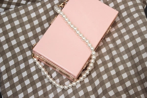 Pink rectangular evening clutch bag with glossy finish and large faux pearl chain strap