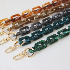 Detail of vintage acrylic resin bag chains with tortoiseshell pattern and gold clasps