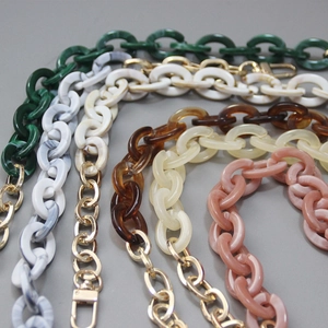 Close-up of five acrylic resin bag chains in assorted marble colors with gold metal clasps