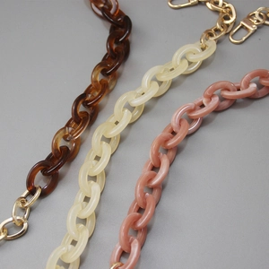 Detail of acrylic bag chains in tortoiseshell, cream and rose pink with gold lobster clasps