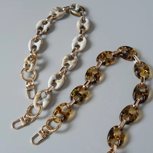 Detail of leopard and marble resin chains with gold metal lobster clasps for bags