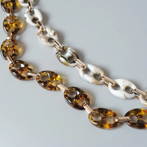 Close-up of leopard resin links with gold metal connectors on decorative chain