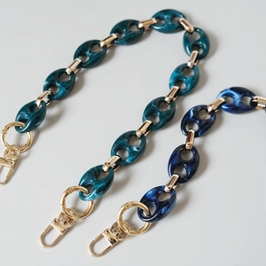 Detail of leopard print acrylic resin bag chains in turquoise and dark blue with gold clasps