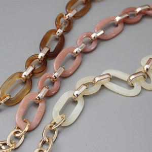 Detail of vintage resin handbag chain straps in amber brown, pink, and cream white colors