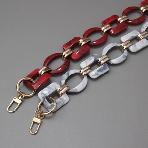 Macro view of vintage marble acrylic resin chains with gold lobster clasps and metal links