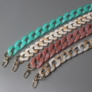 Detail of chunky resin bag chains in mint green, beige, and marble with gold lobster clasps