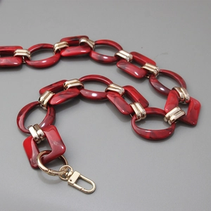 Detail of red marble resin chain strap with gold metal links and lobster clasp hardware