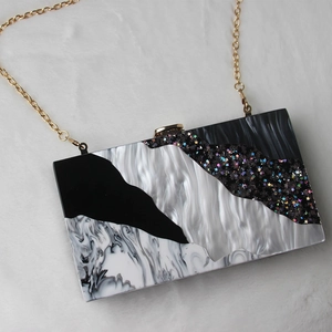 Detail of acrylic evening clutch with black and white marble pattern and star accents
