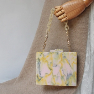 Elegant acrylic marble evening bag with resin chain handle and gold metal accents