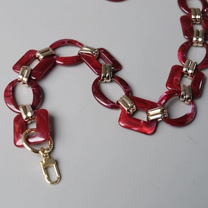 Detail of red marble resin links and gold metal lobster clasps for handbag chains