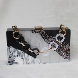 Detail of acrylic clutch bag with black and white marble pattern and star glitter finish