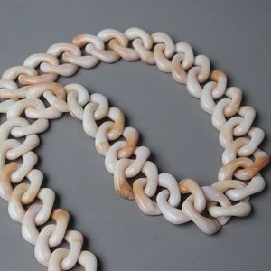Detail view of thick resin chain with beige marble texture for bags and accessories