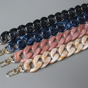 Detail view of multi-color acrylic resin bag straps with gold lobster clasps and marble patterns