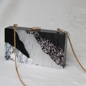 Elegant acrylic clutch bag with marble patterns and gold chain for evening party