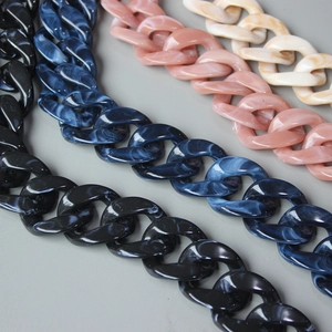 Close-up of colorful acrylic resin chain links for handbags in marble blue, pink and black