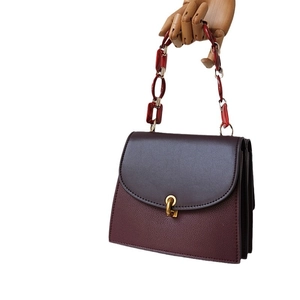 Vintage dark brown leather handbag with red acrylic resin chain and gold hardware detail