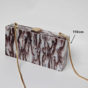 Detail view of marble acrylic clutch with a 110cm gold chain strap and metal clasp