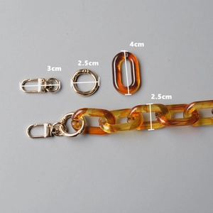 Detailed view of amber resin chain links with golden metal lobster clasps and rings
