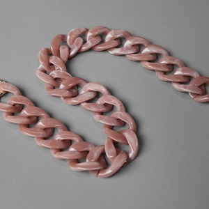 Detail of dusty pink chunky resin bag chain featuring white marble texture and glossy finish