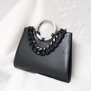 Black leather handbag with colorful acrylic chain and marble-patterned ring handle