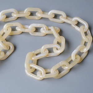Close-up of beige marble-textured acrylic chain links with smooth oval resin design