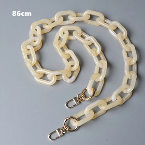 Detail view of 86cm cream acrylic chain strap with marble texture and gold lobster clasps