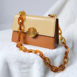 Chic two-tone leather crossbody bag with beige and caramel colors and amber resin chain