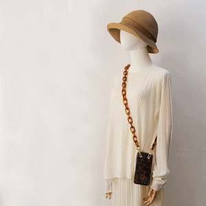 Detail of leopard print phone case with chunky amber resin chain on mannequin