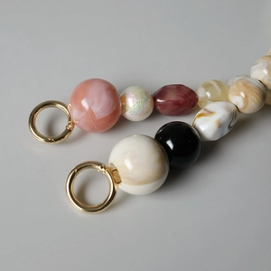 Bandoulière en résine acrylique colorée à texture marbrée avec anneaux métalliques dorés