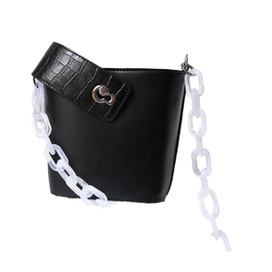 Black leather bucket bag with crocodile texture and white chunky acrylic chain strap