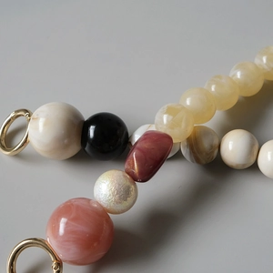 Détail de chaîne en résine colorée avec perles vintage et fermoirs métalliques dorés