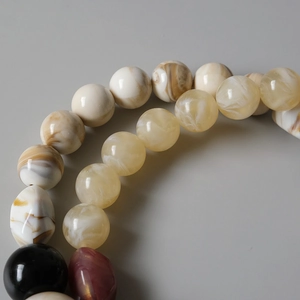 Vue macro de perles en résine acrylique colorées avec texture marbrée pour chaînes de sacs