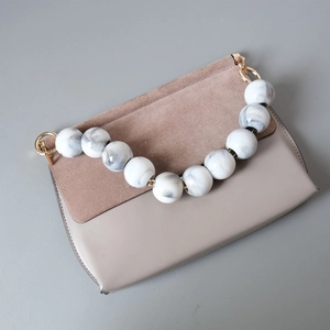 Detail der Clutch aus Wildlederimitat und Marmorperlen am dekorativen Handgriff