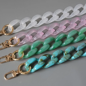 Détail de bandoulières en acrylique coloré avec motifs marbrés et boucles dorées