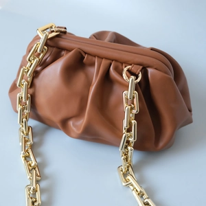 Détail de la grosse chaîne dorée sur la pochette nuage marron à plis sophistiqués