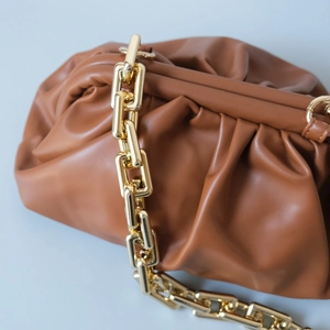 Détail du sac nuage marron foncé avec bandoulière épaisse en chaîne dorée