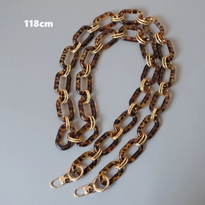 Close-up of a 118cm tortoiseshell resin bag strap with chunky gold metal lobster clasps