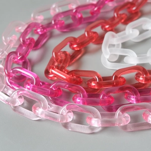 Detail of colorful acrylic resin chain links in red and pink for handbags and DIY crafts