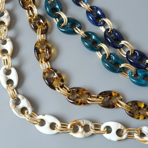 Close-up of resin pig nose link chains with gold metal connectors in various colors
