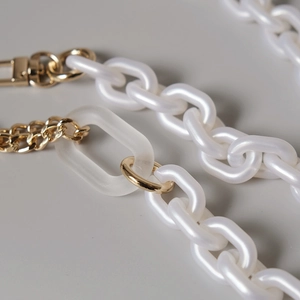 Détail de la chaîne en perles blanches et acrylique dépoli avec fermoir mousqueton doré