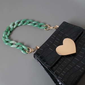 Sac à main texture crocodile avec boucle cœur doré et chaîne acrylique verte