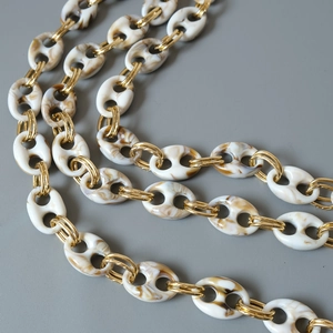 Detailed macro view of marble resin links connected with golden metal double rings