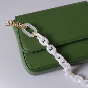 Détail du petit sac carré vert foncé avec chaîne mixte en résine acrylique blanche et métal