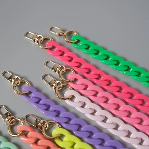 Close-up of colorful acrylic chunky chains with golden lobster clasps for bags
